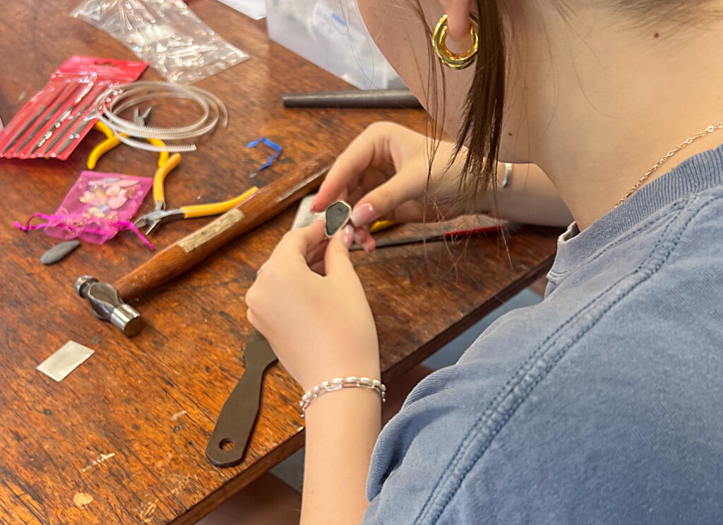 Young maker creating jewelry fabrication crop