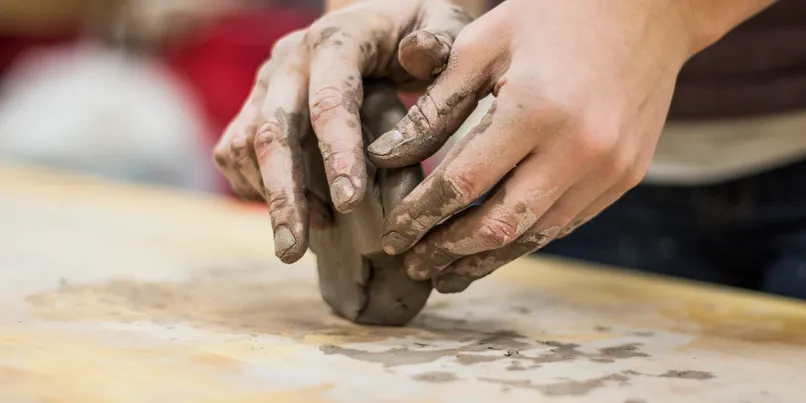 young maker throwing clay